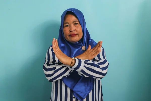 Wściekła Azjatka Średnim Wieku Niebieskim Hidżabie Stoi Skrzyżowanymi Rękami Pokazując — Zdjęcie stockowe