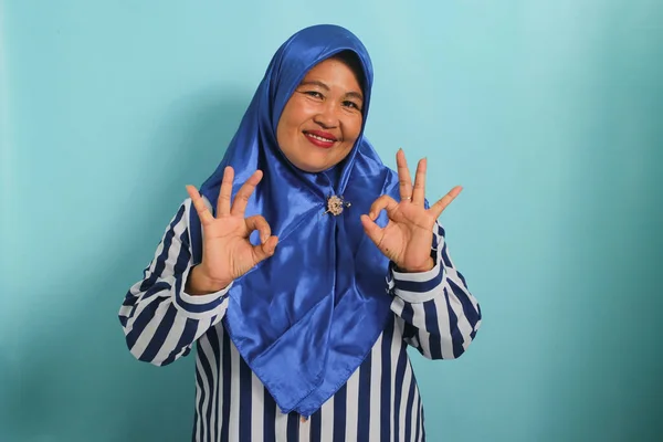 Uśmiechnięta Azjatka Średnim Wieku Niebieskim Hidżabie Koszuli Paski Stoi Niebieskim — Zdjęcie stockowe