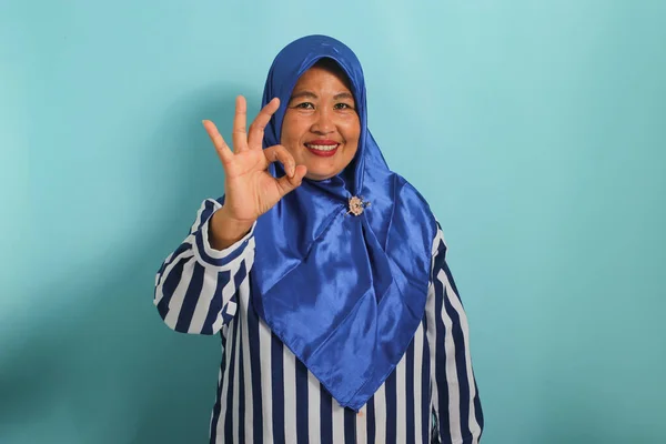 Uśmiechnięta Azjatka Średnim Wieku Niebieskim Hidżabie Koszuli Paski Stoi Niebieskim — Zdjęcie stockowe