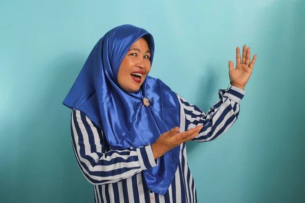Podekscytowana Azjatka Średnim Wieku Niebieskim Hidżabie Koszuli Paski Pokazuje Przestrzeń — Zdjęcie stockowe
