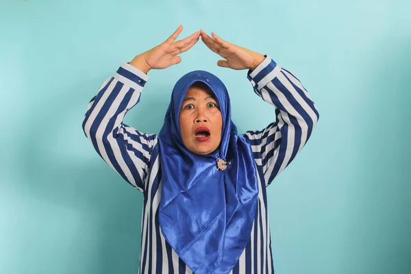Zdziwiona Azjatka Średnim Wieku Niebieskim Hidżabie Koszuli Paski Robi Domowy — Zdjęcie stockowe