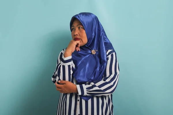 Mavi Tesettürlü Çizgili Tişörtlü Orta Yaşlı Düşünceli Bir Asyalı Kadın — Stok fotoğraf