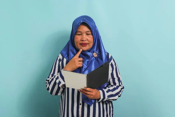 Przemyślana Azjatycka Kobieta Średnim Wieku Niebieskim Hidżabie Koszuli Paski Trzyma — Zdjęcie stockowe