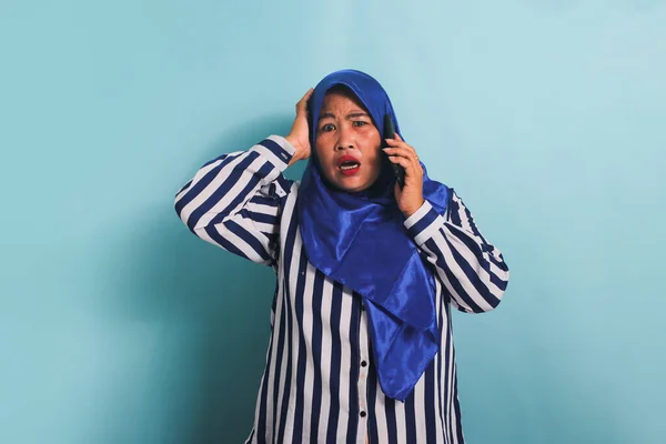 Egy Megdöbbent Középkorú Ázsiai Kék Hidzsábbal Csíkos Ingben Beszél Telefonon — Stock Fotó