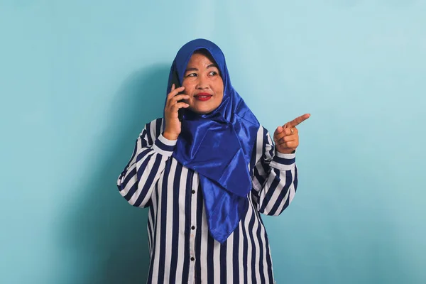 Azjatka Średnim Wieku Niebieskim Hidżabie Pasiastej Koszuli Wskazuje Właściwą Przestrzeń — Zdjęcie stockowe