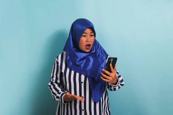 Zszokowana Azjatka Średnim Wieku Niebieskim Hidżabie Koszuli Paski Patrzy Ekran — Zdjęcie stockowe