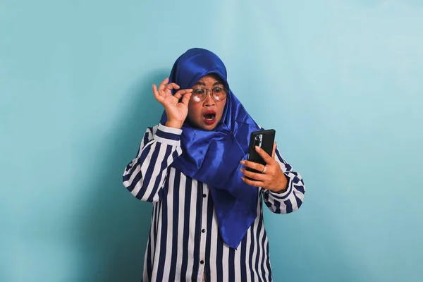 Zszokowana Azjatka Średnim Wieku Niebieskim Hidżabie Koszuli Paski Patrzy Ekran — Zdjęcie stockowe