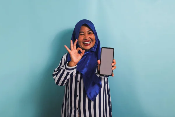 Podekscytowana Azjatka Średnim Wieku Niebieskim Hidżabie Koszuli Paski Trzyma Telefon — Zdjęcie stockowe