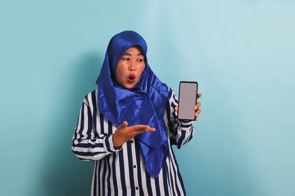 Podekscytowana Azjatka Średnim Wieku Niebieskim Hidżabie Koszuli Paski Pokazuje Telefon — Zdjęcie stockowe