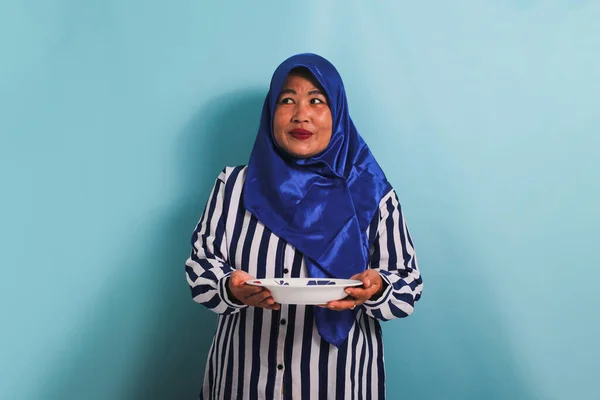 Zamyślona Azjatka Średnim Wieku Niebieskim Hidżabie Koszuli Paski Spogląda Przestrzeń — Zdjęcie stockowe