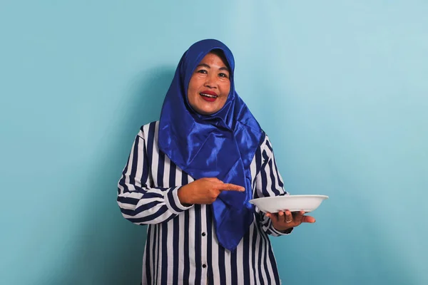 Podekscytowana Azjatka Średnim Wieku Niebieskim Hidżabie Pasiastej Koszuli Wskazuje Biały — Zdjęcie stockowe