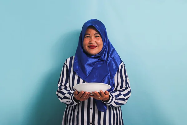 Podekscytowana Azjatka Średnim Wieku Niebieskim Hidżabie Koszuli Paski Stoi Trzyma — Zdjęcie stockowe
