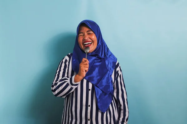 Счастливая Азиатка Средних Лет Синем Хиджабе Полосатой Рубашке Держит Ложку — стоковое фото