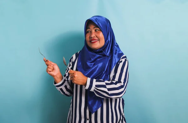 Podekscytowana Azjatka Średnim Wieku Niebieskim Hidżabie Koszuli Paski Wskazuje Lewą — Zdjęcie stockowe