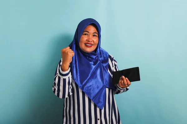 Podekscytowana Azjatka Średnim Wieku Niebieskim Hidżabie Koszuli Paski Trzyma Portfel — Zdjęcie stockowe