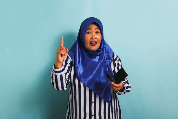Podekscytowana Azjatka Średnim Wieku Niebieskim Hidżabie Pasiastej Koszuli Wskazuje Palcem — Zdjęcie stockowe