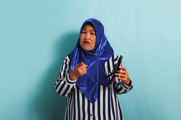 Azjatka Średnim Wieku Niebieskim Hidżabie Pasiastej Koszuli Celuje Kamerę Trzymając — Zdjęcie stockowe