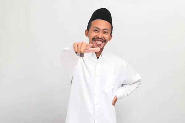 有自信的印度尼西亚年轻人 身穿歌舞 山核桃或Kopiah 用手指对着摄像机笑着 邀请人或招募 这些人都是在白色背景下被隔离的 — 图库照片