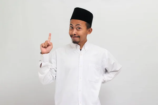 兴奋的年轻印度尼西亚男子 身穿歌舞服 胸衣或Kopiah 指指点点自己 有了新的想法 被白色背景隔离了 — 图库照片