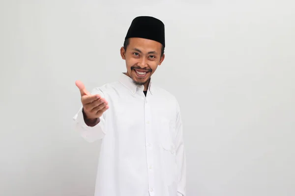自信を持った若いインドネシア人男性は ソングコック ピッチ またはコピアを着て 白い背景で孤立した握手する準備ができています — ストック写真