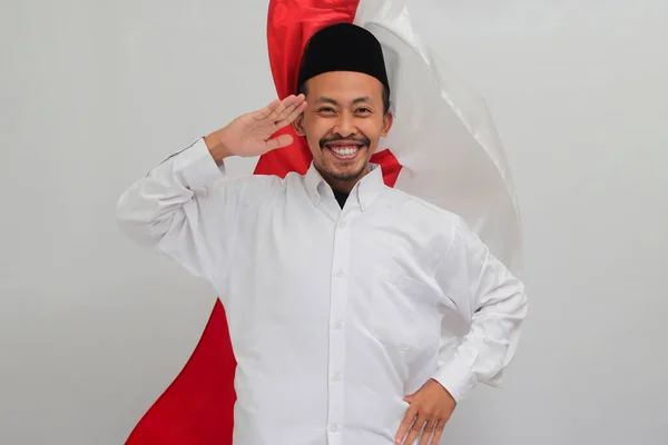 8月17日のインドネシア独立記念日を祝いながら インドネシア国旗を背景にインドネシア国旗に敬意を表する若いインドネシア人男性 — ストック写真
