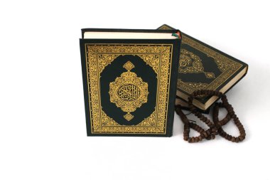 Kuran 'ın anlamı Arapça olan kutsal Kur' an ve beyaz bir zemin üzerine izole edilmiş bir tasbih.