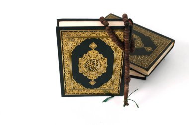 Kuran 'ın anlamı Arapça olan kutsal Kur' an ve beyaz bir zemin üzerine izole edilmiş bir tasbih.
