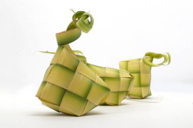 Beyaz zemin üzerinde geleneksel bir Endonezya yemeği olan çoklu ketupat kesesi (örülmüş palmiye yaprakları)