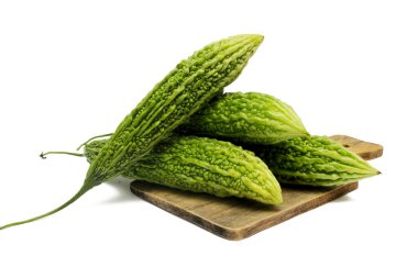Taze kavun (Momordica charantia), ahşap kesme tahtasındaki acı kabak olarak da bilinir. Beyaz arkaplanda izole.