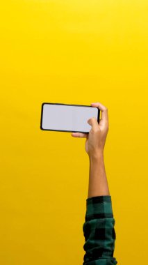 Sarı Arkaplan 'da izole edilmiş Beyaz Ekranlı Bir Telefonu Elle Tutmak