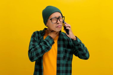 Şapkalı ve sıradan gömlekli genç Asyalı bir adam, boğazı ağrıdığı için internetten bir doktora danışmanlık yapıyor. Acı verici bir yutkunma ve rahatsızlık yaşıyor.