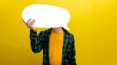 Önünde duran konuşma balonunun arkasında yüzünü gizleyen Asyalı adam, bilgi, düşünce, alıntı, fikir, eleştiri ve geri bildirim kavramlarını tasvir eden sarı bir arkaplana karşı duruyor.