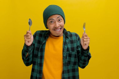 Aç Asyalı bir adam, bereli bir şapka ve günlük bir gömlek giyer, çatal ve kaşıkla dudaklarını ısırır, yaramaz bir ifadeyle kameraya bakar, yoğun açlığını gösterir.