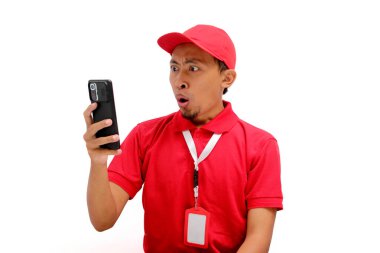 Asyalı bir kurye ya da kurye telefonundaki beklenmedik haberlere tepki veriyor. Beyaz bir arkaplanda izole edilmiş