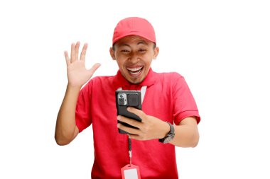 Asyalı bir kurye ya da kurye telefonundaki beklenmedik haberlere tepki veriyor. Beyaz bir arkaplanda izole edilmiş