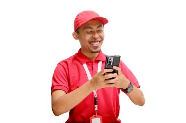 Kendine güvenen Asyalı kurye ya da kurye telefonunu mesaj atmak, teslimatı takip etmek ve stokları kontrol etmek için kullanıyor. Beyaz bir arkaplanda izole edilmiş