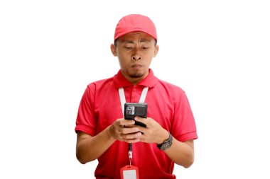 Asyalı mutsuz kurye ya da kurye telefonunu kullanıyor. Kötü haber alırken üzgün ve sinirli. Beyaz bir arkaplanda izole edilmiş