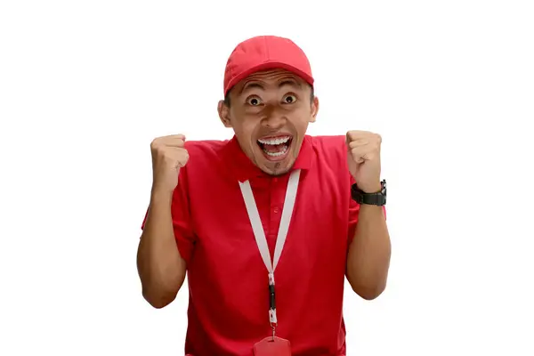 stock image Overjoyed Asian delivery man or courier makes a triumphant gesture by saying 