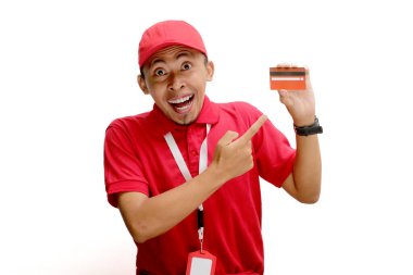 Asyalı kurye ya da kurye beyaz bir arka planda, elinde tutulan bir kredi kartını işaret ediyor. Mali işlemler kavramı, teslimat hizmetlerinde ödeme seçeneklerinin güvenliği