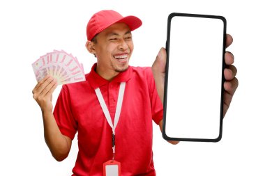 Asian delivery man or courier Showing Blank Phone Screen towards the camera, while holding Money Banknotes, Isolated on white background, new apps, online shopping, logistics, and financial management clipart