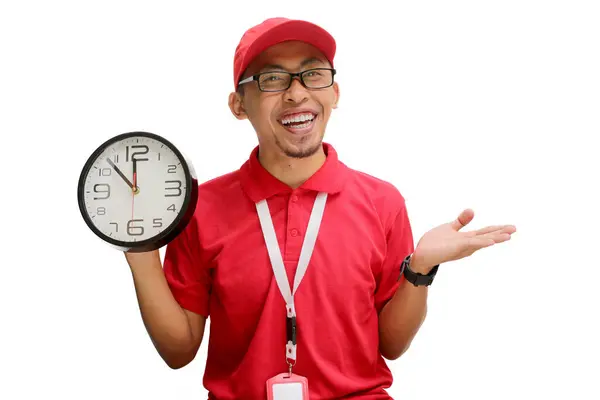 stock image Excited Asian delivery man or courier confidently presents empty copy space to the camera while holding a clock in his hand, isolated on a white background.