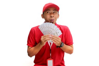 Asyalı kurye elinde dolar banknotları tutuyor, beyaz arka planda izole edilmiş. Mali başarı, talih kuşu, e-ticaret, teslimat hizmetleri ve olumlu mali sonuçlar kavramı