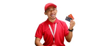 Mutlu Asyalı kurye ya da kurye beyaz bir arka planda izole edilmiş bir kredi kartını tutarken kameraya sıcak bir şekilde gülümser..