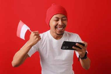 Endonezya Milli Takımı 'nın 17 Ağustos' ta Endonezya Bağımsızlık Günü 'nde Endonezya bayrağını tutarken bir gol atmasını ve maçı telefonla kazanmasını kutluyor.