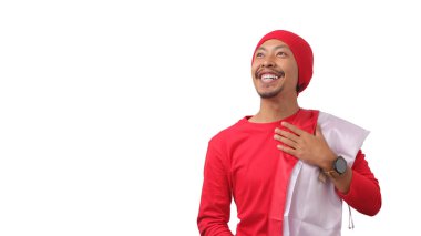 Endonezyalı kırmızı gömlekli adam Endonezya ulusal marşını dinlerken ve 17 Ağustos 'ta Bağımsızlık Günü' nü kutlarken Endonezya bayrağını tutuyor. Beyaz bir arkaplanda izole edilmiş