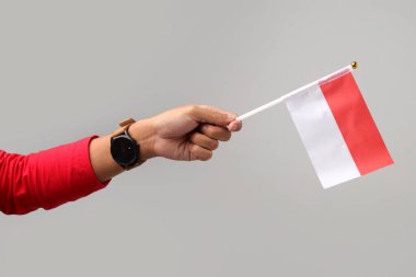 Beyaz arka planda izole edilmiş Endonezya bayrağını tutan el.