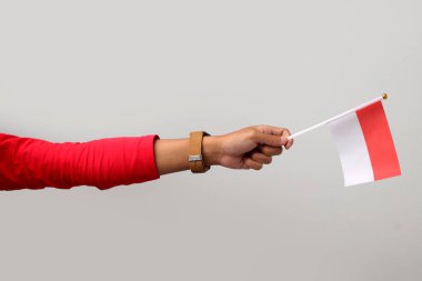 Beyaz arka planda izole edilmiş Endonezya bayrağını tutan el.