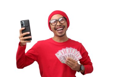 Endonezya 'nın 17 Ağustos' taki Bağımsızlık Günü terfisi sırasında aldığı ikramiye ve nakit parayı beyaz arka planda izole ederek kutlayan Endonezyalı heyecanlı bir adam.