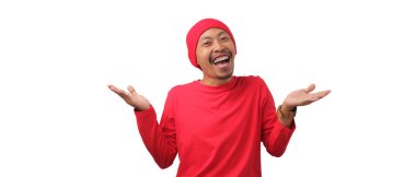 Cheerful Indonesian man wearing a red shirt and beanie extends both palms outward, offering options or choices during Indonesia's Independence Day celebration on August 17 isolated on white background clipart