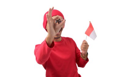 Heyecanlı Endonezyalı gençler 17 Ağustos 'taki Bağımsızlık Günü kutlamalarında kameraya bakarken ve Endonezya bayrağını tutarken iyi bir jestten gizlice bakıyorlar.